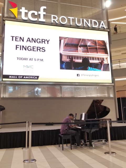 John Sims playing piano in the Mall of America rotunda